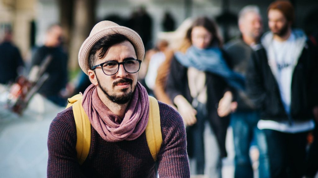 man sitting alone in crowd